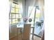 Well-lit office space with a white desk, chair, sheer curtains, and a sliding glass door to the patio at 6826 Stones Throw N Cir # 11305, St Petersburg, FL 33710