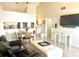 Bright living area with a dining table, leather sofa, ottoman, and a wall-mounted television at 6826 Stones Throw N Cir # 11305, St Petersburg, FL 33710