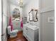 Charming bathroom featuring a decorative mirror, hardwood floors and a window with bright natural light at 701 S Edison Ave, Tampa, FL 33606