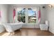Bright bathroom with a clawfoot tub next to large windows at 701 S Edison Ave, Tampa, FL 33606