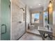 Elegant bathroom with marble tiles, glass shower, modern sink and natural light at 701 S Edison Ave, Tampa, FL 33606