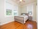 Sun-drenched bedroom with a wooden sleigh bed, hardwood floors, and three windows at 701 S Edison Ave, Tampa, FL 33606