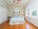 Bright bedroom with hardwood floors, ceiling fan, and a bed featuring storage drawers at 701 S Edison Ave, Tampa, FL 33606