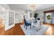 Bright dining room featuring hardwood floors, a glass table, chandelier, and access to other rooms in the home at 701 S Edison Ave, Tampa, FL 33606