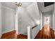 Hallway featuring hardwood floors, white walls and trim, and a staircase with white balusters and a dark handrail at 701 S Edison Ave, Tampa, FL 33606
