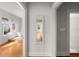 Hallway with hardwood floors leading to a bathroom with a clawfoot tub and other rooms at 701 S Edison Ave, Tampa, FL 33606