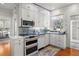 Charming kitchen featuring white cabinetry, stainless steel appliances, stylish backsplash, and a window with natural light at 701 S Edison Ave, Tampa, FL 33606