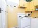 A cozy kitchen features an electric range and vintage yellow cabinetry, providing a classic aesthetic at 701 S Edison Ave, Tampa, FL 33606