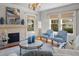 Well-lit living room featuring hardwood floors, a decorative fireplace, comfortable armchairs, and natural light at 701 S Edison Ave, Tampa, FL 33606