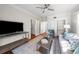 Bright living room featuring hardwood floors, ceiling fan, built-in shelving, and a comfortable seating arrangement at 701 S Edison Ave, Tampa, FL 33606