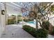 A refreshing pool area enhanced with shade trees, a decorative pergola, and stone paver patio at 701 S Edison Ave, Tampa, FL 33606