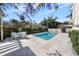 Tranquil in-ground pool surrounded by lush greenery, mature trees and a stone paver patio and pergola at 701 S Edison Ave, Tampa, FL 33606