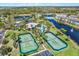 Aerial view of community pool, clubhouse, tennis courts, ponds, and surrounding properties at 7040 Key Haven Rd # 606, Seminole, FL 33777