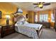 Bright main bedroom with warm colors, a decorative ceiling, a ceiling fan, and detailed wood furniture at 7040 Key Haven Rd # 606, Seminole, FL 33777