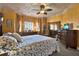 Bright main bedroom with warm colored walls, decorated ceiling, mirror, and dresser at 7040 Key Haven Rd # 606, Seminole, FL 33777