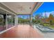 Covered porch offering a seamless transition to a pool and lake views with wooden floors at 7820 Marsh Pointe Dr, Tampa, FL 33635