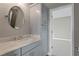 Cozy bathroom showcasing gray cabinetry, elegant marble countertop, and a round mirror at 7820 Marsh Pointe Dr, Tampa, FL 33635