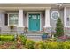 Inviting front entry with a teal door, white pillars, stone accents and vibrant landscaping at 7820 Marsh Pointe Dr, Tampa, FL 33635