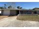Charming single-story home with a well-maintained lawn and attached garage, exuding curb appeal at 8708 Robilina Rd, Port Richey, FL 34668