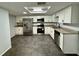 Modern kitchen featuring stainless steel appliances, white cabinetry and granite countertops at 8708 Robilina Rd, Port Richey, FL 34668