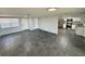 Open-concept living room with sleek tile flooring and natural light, leading to the kitchen at 8708 Robilina Rd, Port Richey, FL 34668