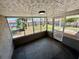 Enclosed porch area overlooking a fenced backyard, offering privacy and outdoor living space at 8708 Robilina Rd, Port Richey, FL 34668