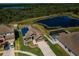 Beautiful aerial view of home featuring pond views, solar panels, and a screened-in pool at 9211 Seeger Ln, Land O Lakes, FL 34638