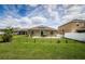 Spacious backyard featuring a covered patio, a well-manicured lawn, and partial fencing at 9211 Seeger Ln, Land O Lakes, FL 34638