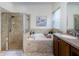 Bathroom featuring glass shower and a soaking tub with tile surround at 9211 Seeger Ln, Land O Lakes, FL 34638