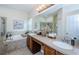 Bathroom featuring dual sinks, large mirrors, and a soaking tub with tile surround at 9211 Seeger Ln, Land O Lakes, FL 34638