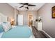 Bright main bedroom features wood floors, ceiling fan, dresser, and ensuite bathroom at 9211 Seeger Ln, Land O Lakes, FL 34638