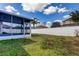 A spacious and well-manicured backyard featuring a covered patio and a pristine white fence at 9407 Black Thorn Loop, Land O Lakes, FL 34638