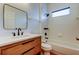 Bright bathroom with wood vanity, modern fixtures, and tile shower/tub combo at 9407 Black Thorn Loop, Land O Lakes, FL 34638