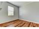 Bedroom with wood-look flooring, neutral paint, and natural light from the window at 9407 Black Thorn Loop, Land O Lakes, FL 34638