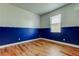 Bright bedroom features striking blue accent wall and wood-look laminate flooring at 9407 Black Thorn Loop, Land O Lakes, FL 34638