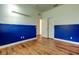 Bedroom with blue accent wall, wood-look flooring, closet, and neutral paint at 9407 Black Thorn Loop, Land O Lakes, FL 34638