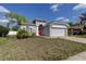 Charming single-story home with gray exterior, a bright red front door, and a well-manicured lawn at 9407 Black Thorn Loop, Land O Lakes, FL 34638