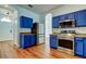 Kitchen featuring stainless steel appliances, blue cabinets, and modern light fixtures at 9407 Black Thorn Loop, Land O Lakes, FL 34638