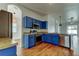 Open kitchen featuring stainless steel appliances, blue cabinets, and modern light fixtures at 9407 Black Thorn Loop, Land O Lakes, FL 34638