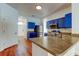 Open kitchen with stainless steel appliances and blue cabinets, and wood-look flooring at 9407 Black Thorn Loop, Land O Lakes, FL 34638