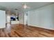 Large living room with wood floors, ceiling fan, and view of the kitchen at 9407 Black Thorn Loop, Land O Lakes, FL 34638