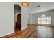 Open-concept living area with hardwood floors, arched doorways, natural light, and access to the kitchen at 9407 Black Thorn Loop, Land O Lakes, FL 34638
