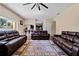 Open concept living room with hardwood floors, leather sofas, area rug and a view of the kitchen at 9614 Orange Jasmine Way, Tampa, FL 33647