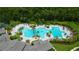 Aerial view of a resort-style community pool area, featuring multiple pools, palm trees, and lounge chairs at 9614 Orange Jasmine Way, Tampa, FL 33647