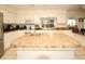 Bright kitchen with large island featuring tile countertops and stainless steel appliances at 9805 Hermosillo Dr, New Port Richey, FL 34655