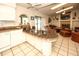 Open-concept kitchen and living room with stone fireplace and sliding glass doors to lanai at 9805 Hermosillo Dr, New Port Richey, FL 34655