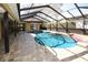 Relaxing enclosed pool with brick paver patio, providing a tranquil backyard retreat at 9805 Hermosillo Dr, New Port Richey, FL 34655