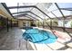 Relaxing enclosed pool with brick paver patio, providing a tranquil backyard retreat at 9805 Hermosillo Dr, New Port Richey, FL 34655