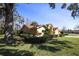 Charming side view of a well-maintained home with lush greenery and mature trees at 9805 Hermosillo Dr, New Port Richey, FL 34655
