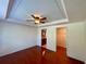 A spacious bedroom with hardwood floors, ceiling fan, and views to bathroom and closet at 902 Estelle Ave, Brandon, FL 33511